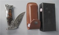 Ornate pocket knife with leather sheath.