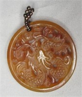 Antique carved pendant amber in color.