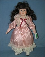 Porcelain doll in pink dress with glass eyes