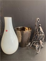 A glass vase, ceramic pot, and a plant holder.