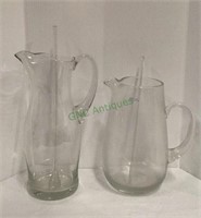 Two large glass beverage pitchers both with glass