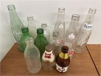 Baker’s dozen of vintage beverage bottles.