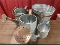 Three galvanized decorative watering cans and a
