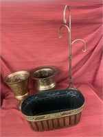 Mismatched copper vases, a basket and a plant