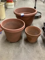 Two plastic and one terra-cotta garden planter