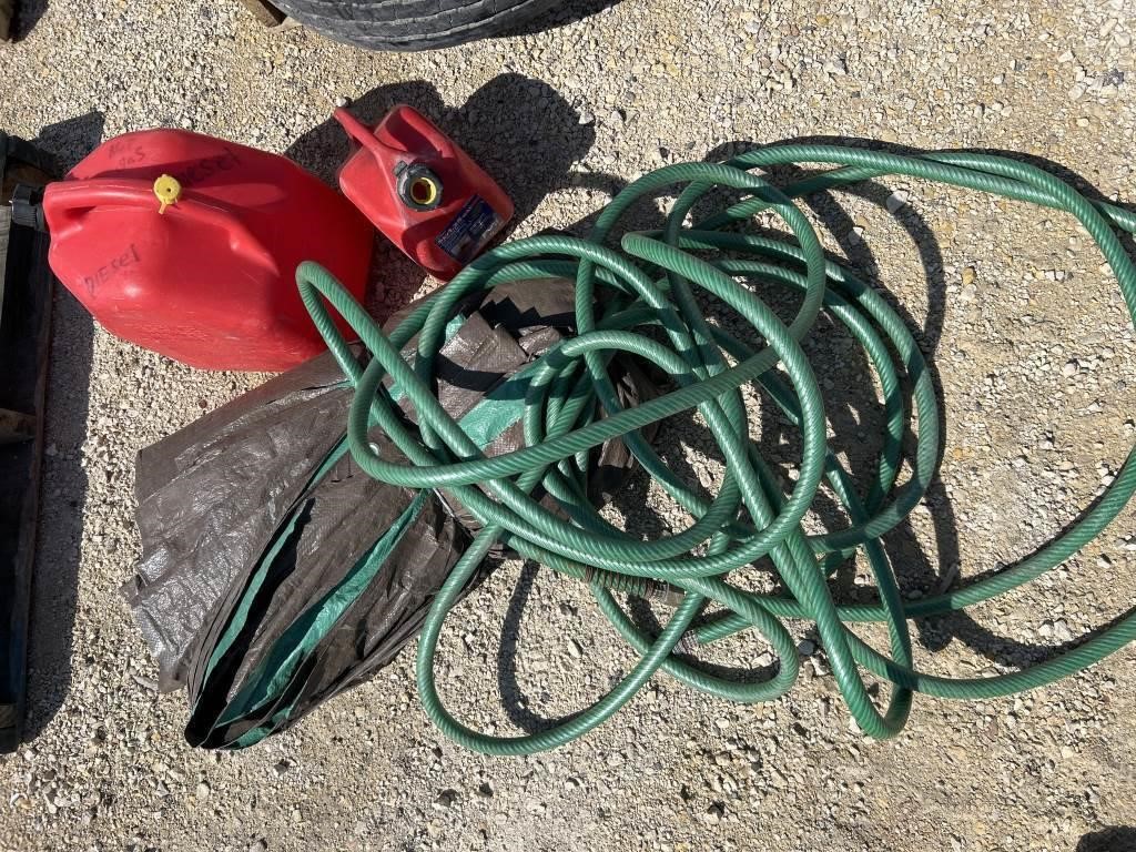 2 assorted gas cans, a tarp and a garden hose