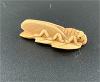 Antique mammoth netsuke of a cicada resting on a l