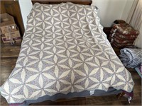 Large floral patter quilt w stack of linens
