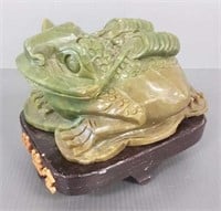 Carved stone toad figure on wooden base