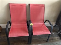 2 red stackable patio chairs