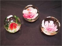 Three paperweights, all floral, one with flying