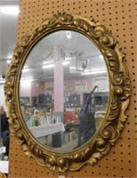 Oval mirror in ornate frame, 21" x 25"