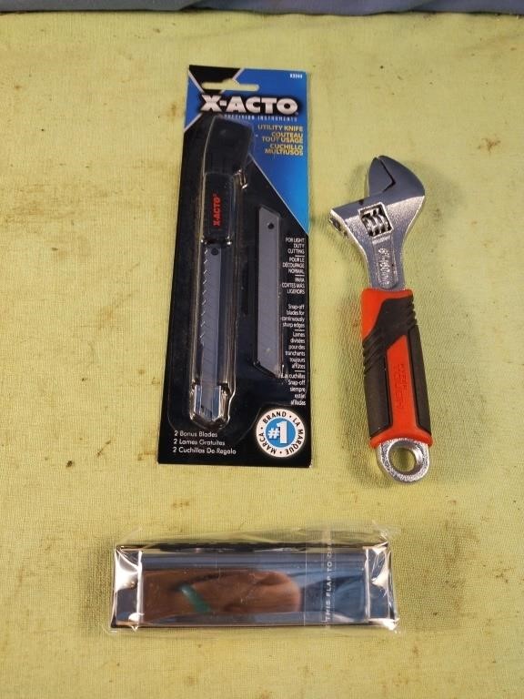 X-Acto knife, adjustable wrench and harmonica