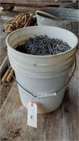 5 GALLON BUCKET CONTAINING FENCE STAPLES