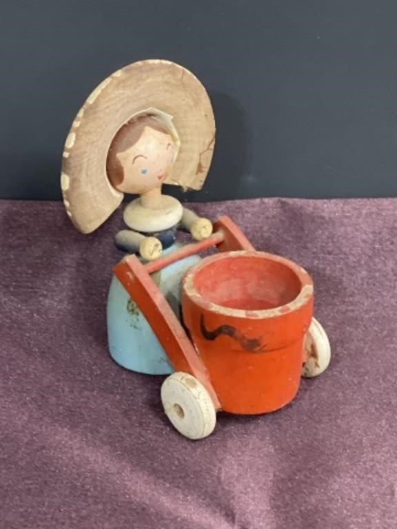 Vintage wood figurine lady pushing basket