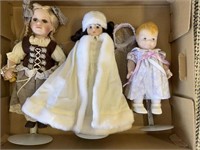 3 porcelain dolls on stands