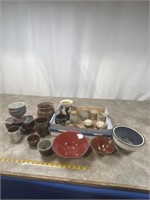 Assortment of pottery cups, bowls, strainer, and