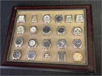 Collection watch faces displayed on framed glass