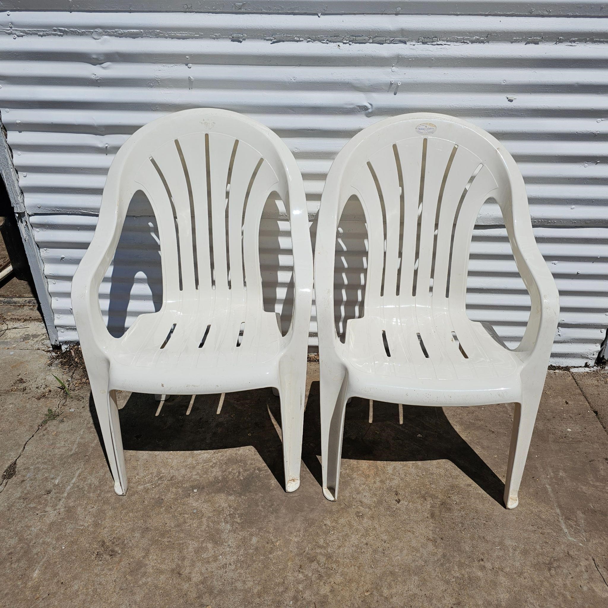 2 white plastic chairs