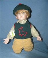 Porcelain boy doll with back pack and hat