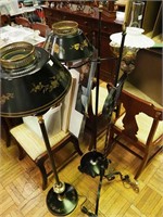 Three black metal floor lamps: two with black