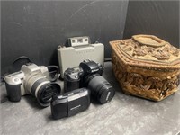 4 Vintage Cameras and a wicker sewing basket.