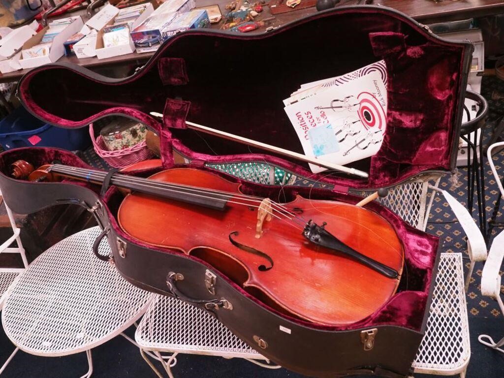 cello in hard case with music books