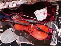 cello in hard case with music books