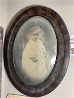 Framed baby picture in oval frame, convex glass
