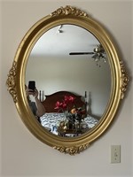 Oval gold framed mirror with rose accents