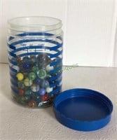 Plastic canister filled with assorted marbles and