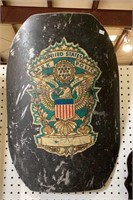 Metal shield. This one has the insignia of the