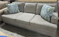 Modern gray upholstered sofa with nailhead trim