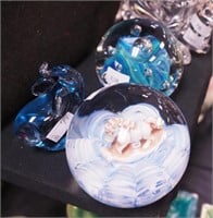 Three paperweights, all with blue accents