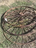 Three antique metal wagon wheels.