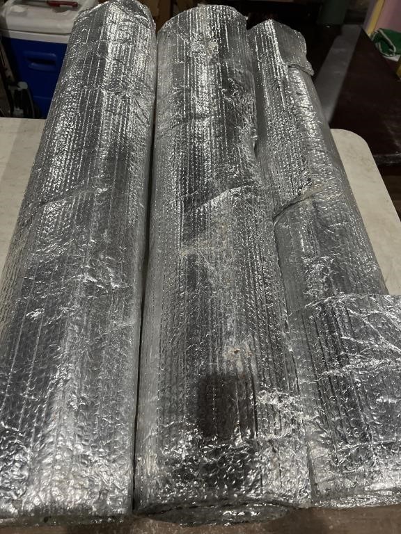 Three partial rolls of metal roofing insulation