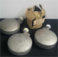 Three military canteens and a canteen holder