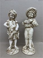 Boy and girl statues holding fruits and vegetables