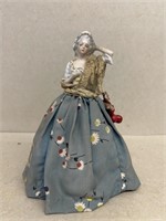 Porcelain doll over storage jar