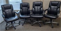 Four black office chairs