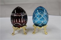 Two crystal eggs on metal gold finish stands,