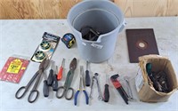 Bucket of assorted tools including tin snips,