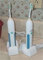 two Phillips Sonicare electric toothbrushes
