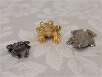Three small metal frogs one is a clip
