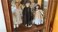 (3) porcelain dolls on middle shelf