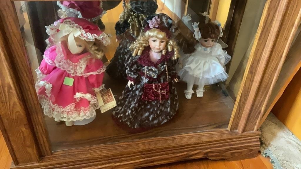 (3) porcelain dolls on bottom shelf