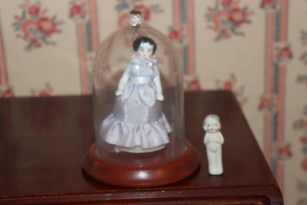 Miniature porcelain doll in display case with tag